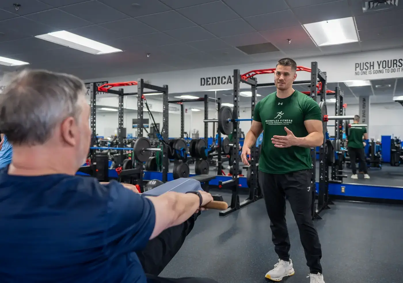 Trainer coaching an older client through a standing strength movement