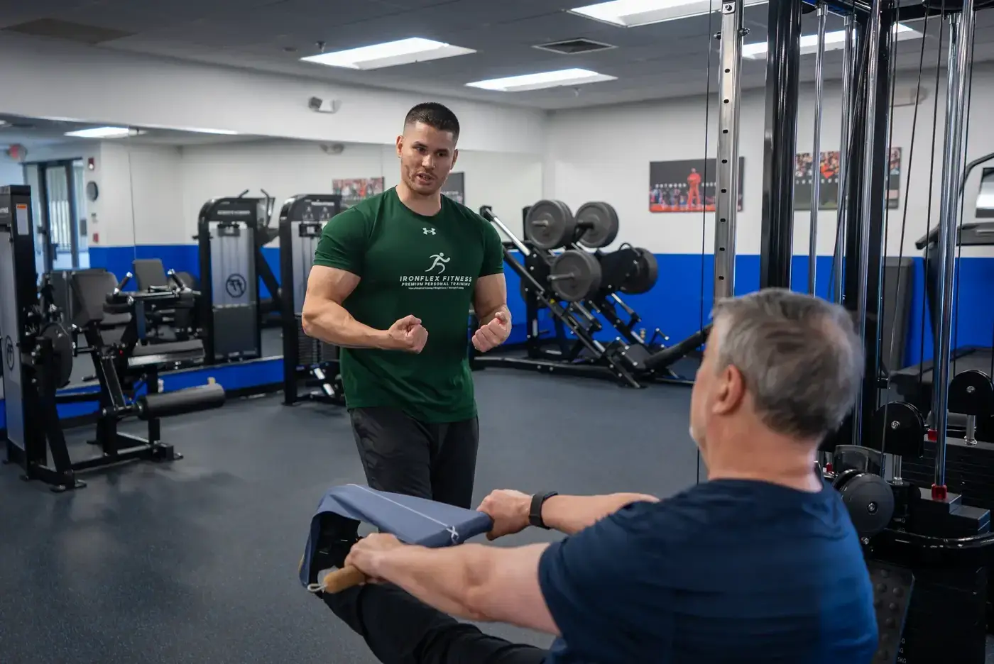 IronFlex trainer coaching a client through a loaded leg exercise