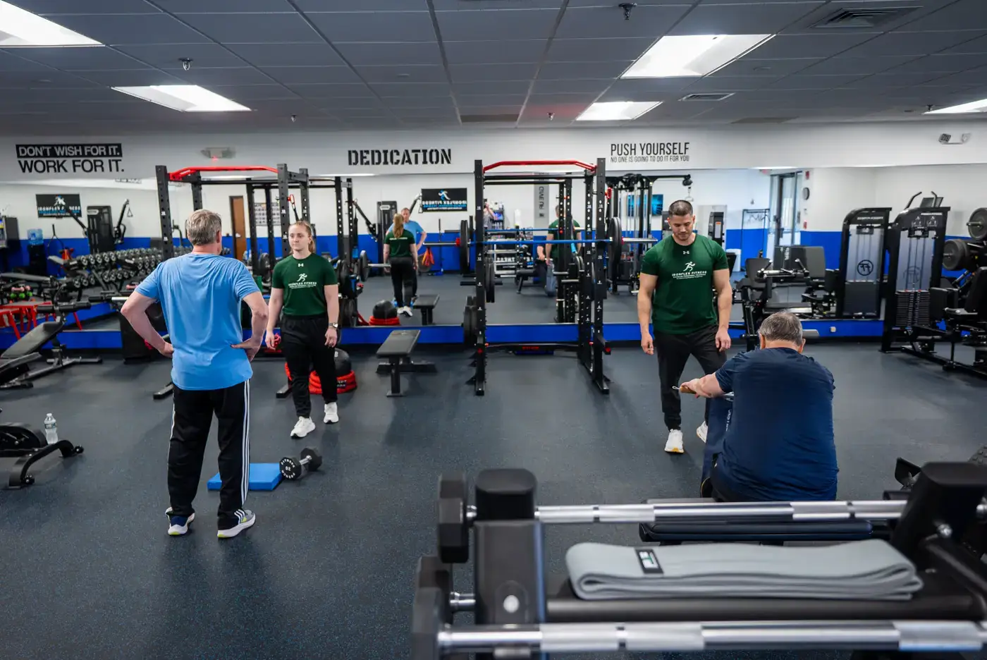 Several IronFlex trainers working with clients across the studio floor