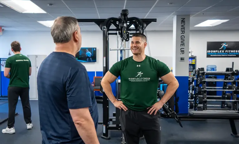 Trainer talking with a client between sets