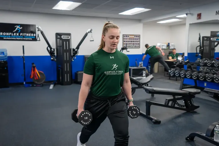 Trainer demonstrating a dumbbell movement