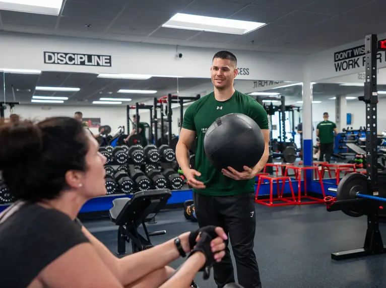 Trainer coaching a client with a medicine ball