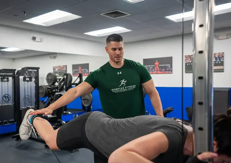 Trainer supporting a client through a pressing movement