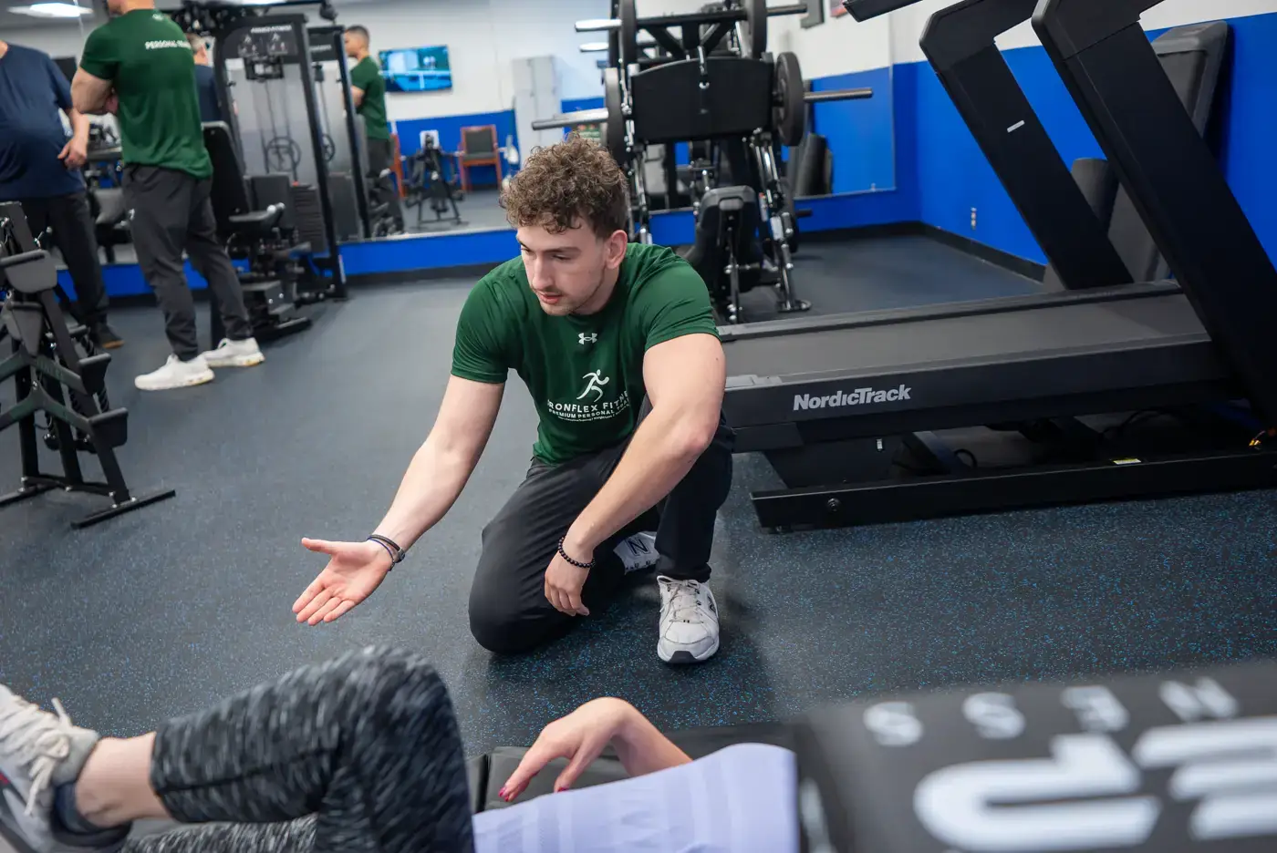 Trainer guiding a client through floor-based mobility work