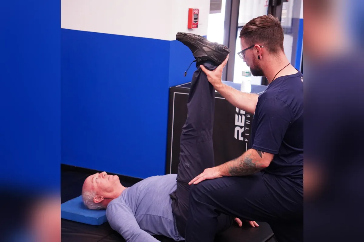 Michael guiding a client through an assisted hamstring stretch