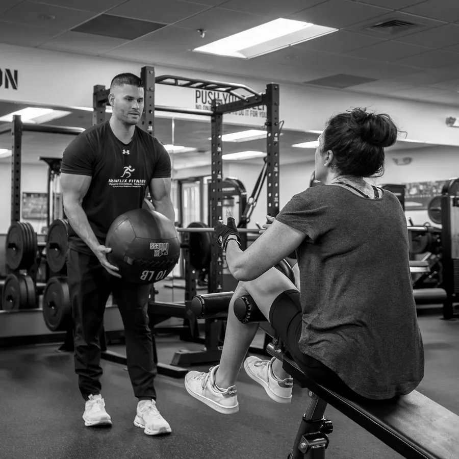 Connor Crouse coaching a client on the bench at IronFlex