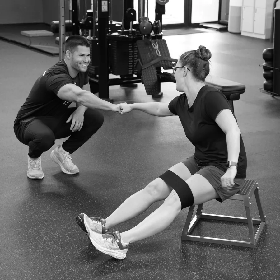 Connor Crouse coaching a client through a squat at IronFlex