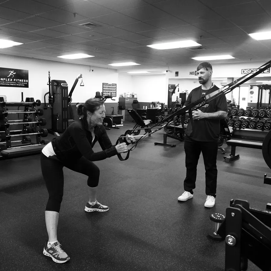 Michael O'Rourke coaching a client through a TRX row at IronFlex